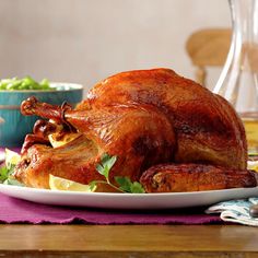 a roasted turkey on a white plate with garnish