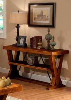 a wooden table with books and vases on it in front of a framed photograph