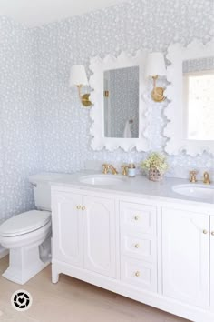 a white bathroom with two sinks and a toilet in it's centerpieces