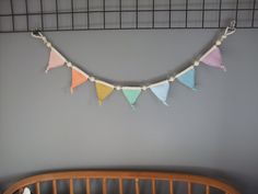 a crocheted bunting is hanging on the wall next to a baby crib