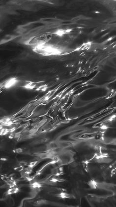 black and white photograph of water ripples on the surface with light reflecting off them