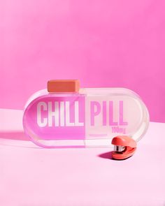 an empty pill bottle sitting on top of a pink surface