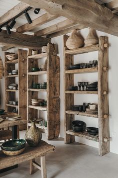 a room with wooden shelves filled with pots and pans