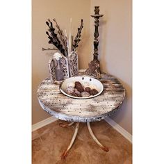 a table with two vases on top of it and an empty plate in the middle