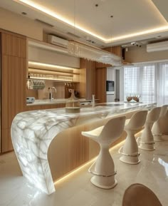 an elegant kitchen with marble counter tops and white stools in front of the bar