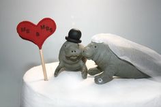 an elephant and turtle figurine on top of a cake with a heart shaped sign