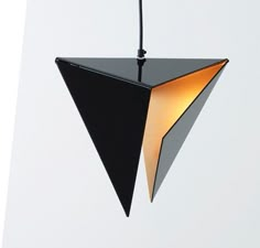 a black and white light hanging from a ceiling fixture with a yellow light in the middle