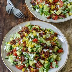 two plates filled with salad on top of a wooden table