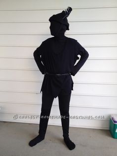 a man in a black ninja suit standing with his hands on his hips