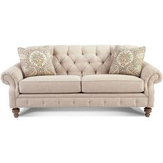 a beige couch with two pillows on it