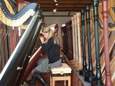 a woman sitting on a bench next to a harp