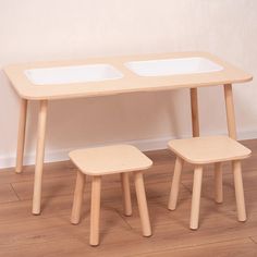 two wooden stools sitting next to a table on top of a hard wood floor