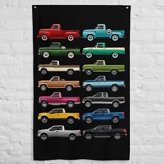 a black wall hanging with colorful trucks on it