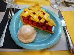 a blue plate topped with a piece of pie next to whipped cream and strawberries