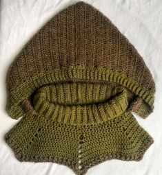 two knitted sweaters laying on top of each other, one green and the other brown