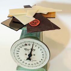 an old fashioned clock with different types of papers on it's face and sides