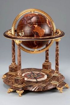 an antique clock with a globe on it