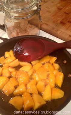 the food is being cooked in the pan on the stove top with a wooden spoon