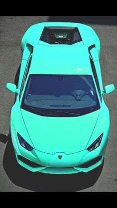 a bright blue sports car parked in a parking lot with its hood up and the top down