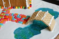 a cake decorated with marshmallows, candy bars and a cracker bridge