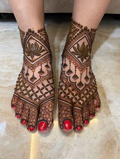 a woman's feet with hennap and red toenails on it