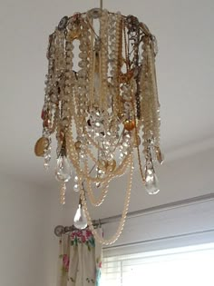 a chandelier hanging from the ceiling in a room with white walls and curtains