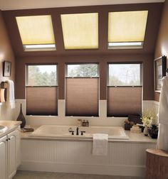 a bath room with a tub a sink and two windows in it's center