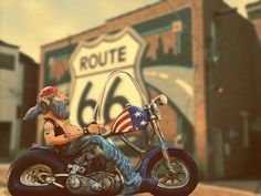 a statue of a man on a motorcycle with the route 66 sign in the background