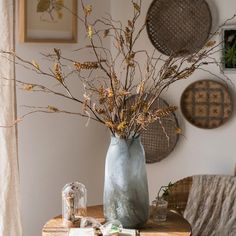 a vase filled with dried flowers on top of a table