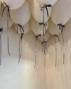 white balloons tied to the wall with black ribbons