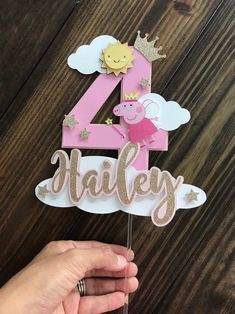 a pink and white cake topper with the number four in gold glitter on it