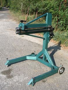 a large green machine sitting on the side of a road