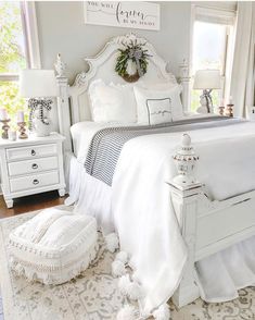 a bedroom with white furniture and decor