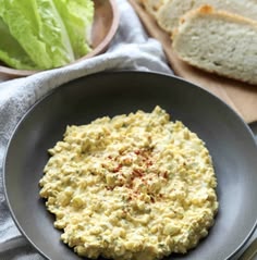 a bowl filled with hummus next to some bread