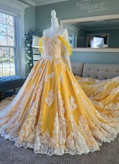 a yellow and white wedding gown on display in a room with blue carpeted walls