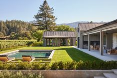 a house with a pool in the middle of it and some chairs on the lawn