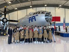 a group of people standing in front of an airplane