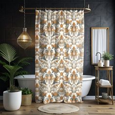 a bathroom with a bathtub, rug and shower curtain that has an orange flower pattern on it