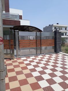 a checkered floor in front of a building with a fence and gate on the other side