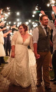 a bride and groom walking down the street with sparklers in their hands