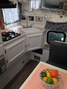 a bowl of fruit is sitting on the kitchen counter in a camper that has been converted into a bed