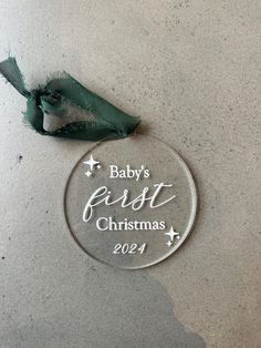 a baby's first christmas ornament with a green ribbon hanging from it