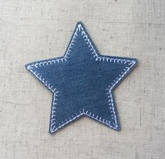 a blue star with white stitching is on a piece of fabric that has been sewn