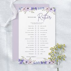 a purple and white flowered bridal checklist with ribbon on the table next to it