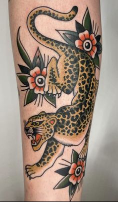 a tattoo with a leopard and flowers on it