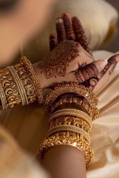 a woman's hands with hennap and bracelets