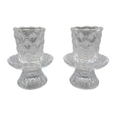 two clear glass candlesticks sitting on top of each other