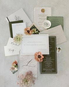 the wedding stationery is laid out on top of each other with flowers and cards