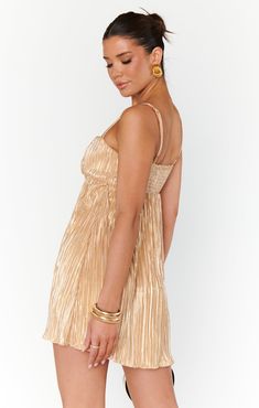 The GNO gold metallic mini features front rose accent, adjustable straps, gold pleat fabric, and smocked back. The perfect mini for fall and holiday parties! White Strappy Heels, Cami Nyc, Pleated Mini Dress, Pleated Fabric, Solid & Striped, Show Me Your Mumu, Trina Turk, Show Me Your, Gold Dress