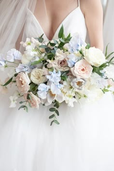 a bridal holding a bouquet of white and blue flowers